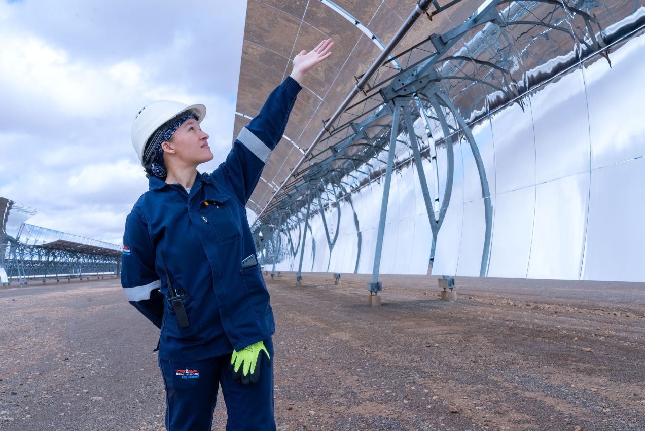 Frau zeigt auf Photovoltaikanlage