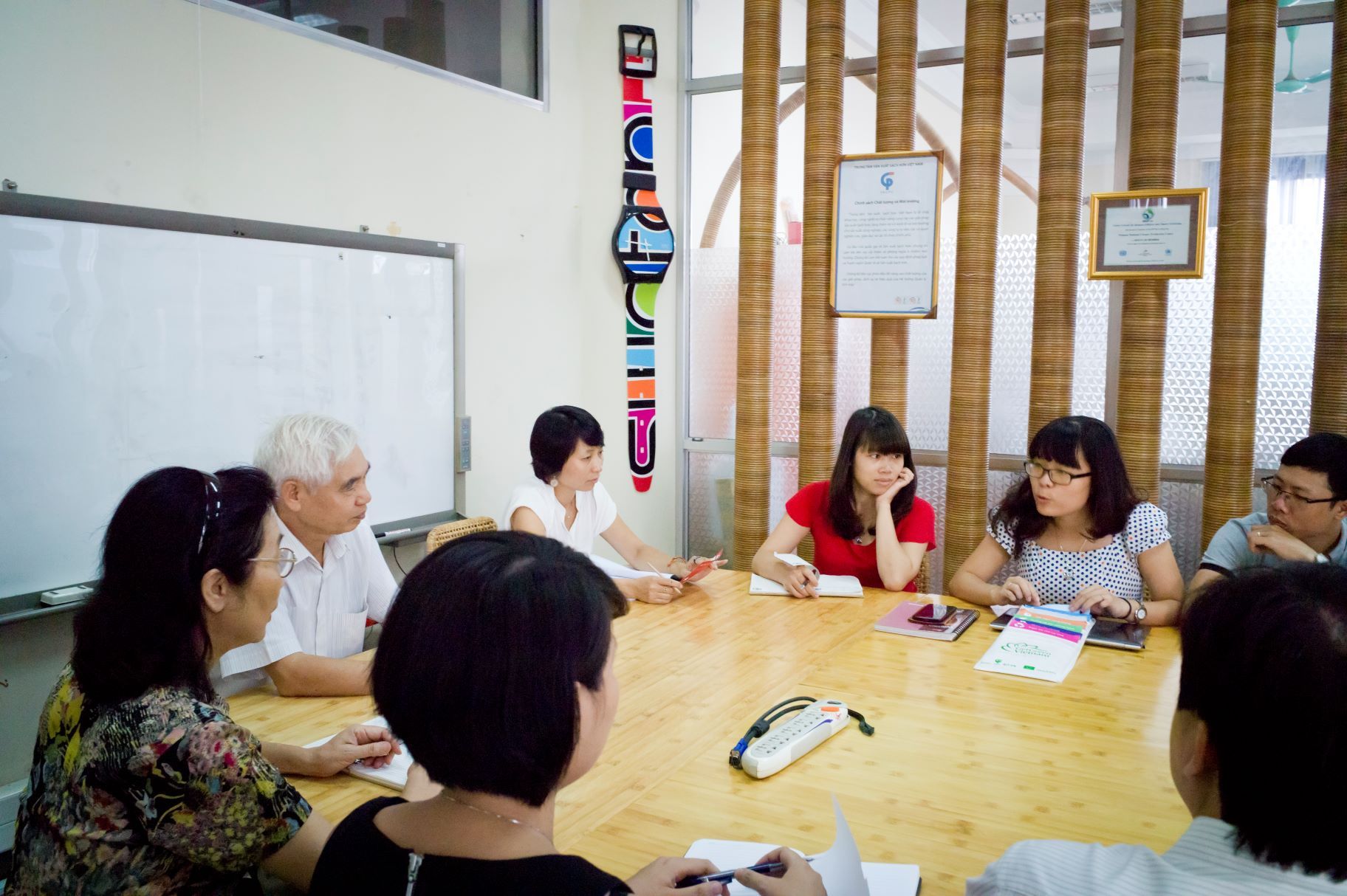 people sitting at a meeting table and discussing