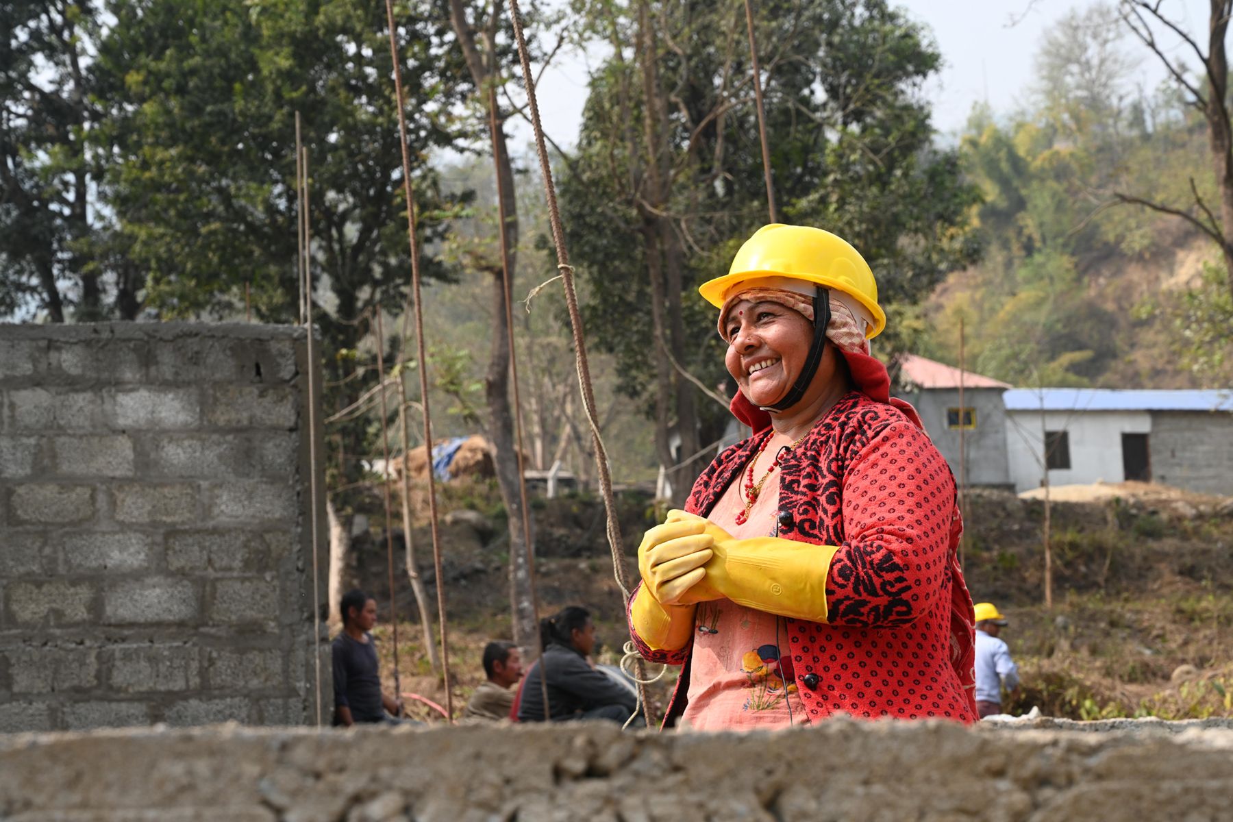 Woman in work clothes takes part in a house construction