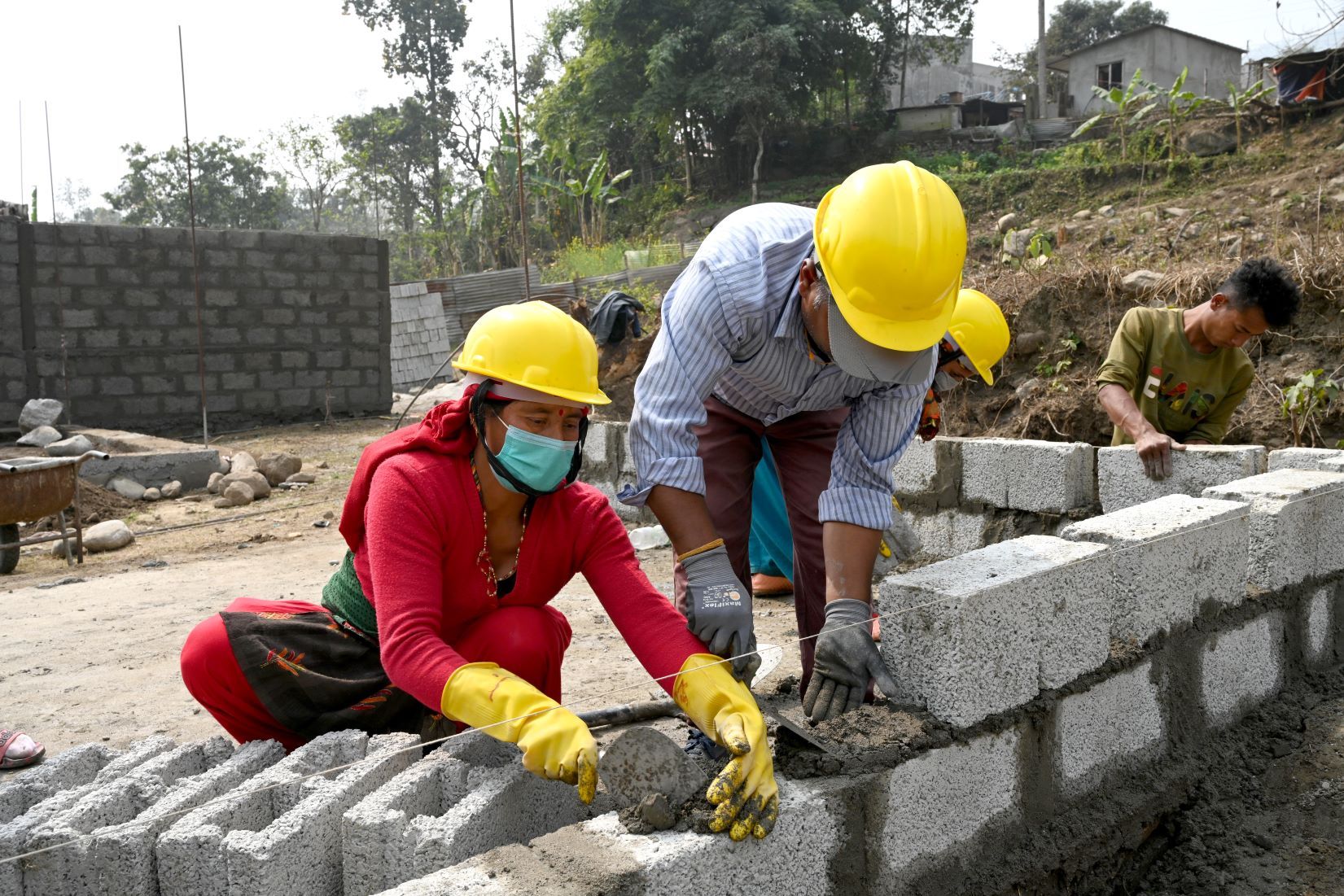 Un homme et une femme construisent un mur de maison